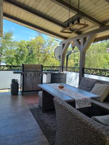 eine Terrasse mit Tisch und Grill in der Unterkunft Chata Domaša David in Bžany