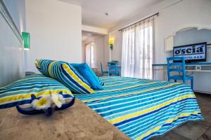 a bedroom with two beds with blue and yellow at Hotel O'scià in Lampedusa