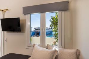 a room with a window with a view of a cruise ship at Alexander Seaview Haven in Ermoupoli