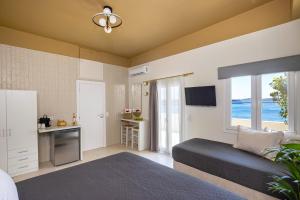 a bedroom with a bed and a kitchen with a window at Alexander Seaview Haven in Ermoupoli