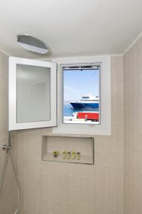 a window in a bathroom with a ship in the water at Alexander Seaview Haven in Ermoupoli +43 photos
