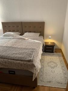 a bedroom with a large bed and a nightstand with a bed sidx sidx sidx at Golden Lilly Apartment in Bihać +7 photos