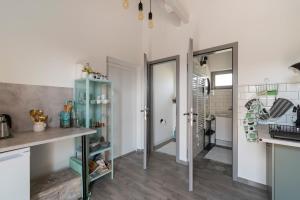 a kitchen with white walls and wooden floors at 1HA Tagyon Vendégház in Tagyon +16 photos
