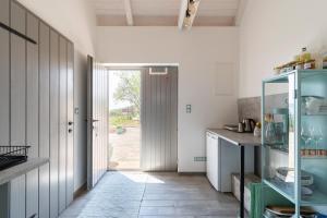 a kitchen with a hallway with a glass cabinet at 1HA Tagyon Vendégház in Tagyon