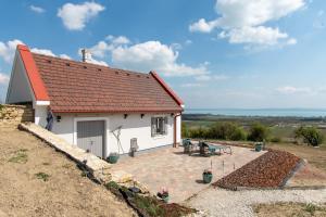 a small white cottage with a red roof at 1HA Tagyon Vendégház in Tagyon