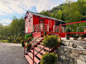 a red house with a staircase leading up to it at Eça River Bungalov in Ayder Yaylasi