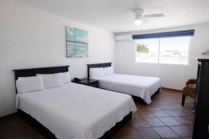 a hotel room with two beds and a window at Playa Inn Rocky Point in Puerto Peñasco