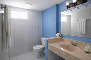 a bathroom with a sink and a toilet and a mirror at Playa Inn Rocky Point in Puerto Peñasco +32 photos