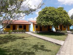 a yellow house with a tree in front of it at Torre do Sol Park Hotel in Chapadinha