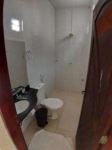 a bathroom with a white toilet and a sink at Torre do Sol Park Hotel in Chapadinha