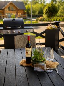 a bottle of wine and a glass on a wooden table at Vila Valentina Luxury Chalet in High Tatras in Veľká Lomnica