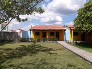 a yellow house with a yard in front of it at Torre do Sol Park Hotel in Chapadinha +5 photos