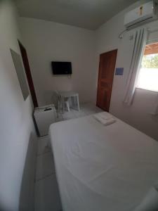 a white bedroom with a bed and a television at Torre do Sol Park Hotel in Chapadinha