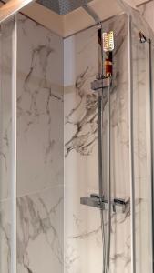 a bathroom with a shower with white marble walls at The Mastiffs in Chioggia