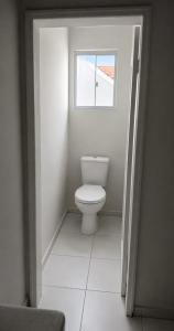 a bathroom with a toilet and a window at ParaHouse in Joinville