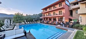 a hotel with a swimming pool in front of a building at Sandy Bay Hotel in Plomari