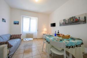 a living room with a table and a couch at Casa Al Caprifoglio - Ispra Apartment 600m From Beach - Happy Rentals in Ispra