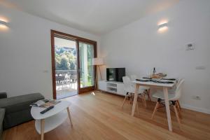 a white living room with a table and a couch at Argegno Home in Argegno