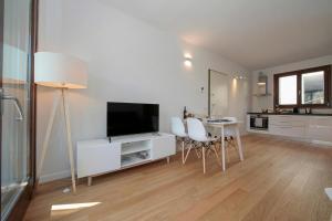 a living room with a television and a table with chairs at Argegno Home in Argegno +15 photos