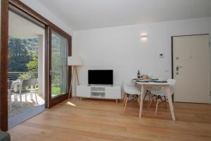 a living room with a television and a table with chairs at Argegno Home in Argegno