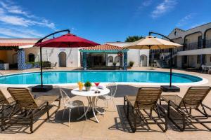 a patio with a table and chairs and a pool at Playa Inn Rocky Point in Puerto Peñasco