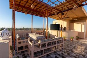 a patio with a table and chairs on a roof at El Agamy Hotel Apartment in Luxor