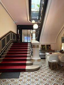 a lobby with a staircase with a red and white carpet at Salon Boyer in Épernay