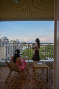 two girls sitting in chairs on a balcony at Manditel North Pattaya in North Pattaya