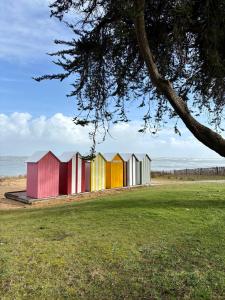 a row of colorful beach huts on the beach at Doudou House in Saint-Denis-dʼOléron