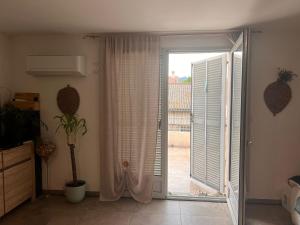 a room with a sliding glass door with a window at F3 CENTRE de ST-FLORENT in Saint-Florent +5 photos