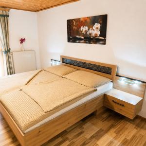 a bedroom with a bed and a painting on the wall at Ferienwohnung Langwallner in Grossarl