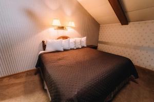 a small room with a bed with two pillows at Riverside Motor Lodge - Pigeon Forge in Pigeon Forge