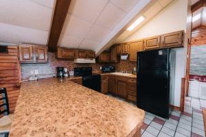a kitchen with a black refrigerator and wooden cabinets at Riverside Motor Lodge - Pigeon Forge in Pigeon Forge