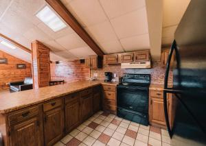 a kitchen with wooden cabinets and a black stove at Riverside Motor Lodge - Pigeon Forge in Pigeon Forge
