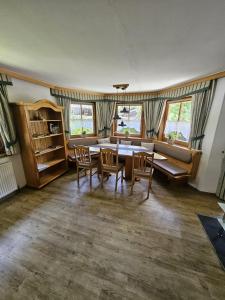 a dining room with a table and chairs and windows at Ferienwohnung Langwallner in Grossarl