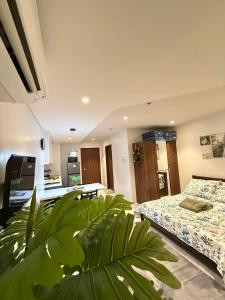 a bedroom with two beds and a plant at Go Q Tambuli Seaside Studio in Maribago +36 photos