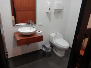 a bathroom with a white toilet and a sink at Hostal Patio del Río in Cali +39 photos