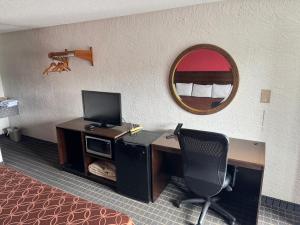 a room with a desk with a computer and a mirror at Bonifay Inn in Bonifay