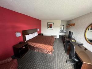 a hotel room with a bed and a flat screen tv at Bonifay Inn in Bonifay