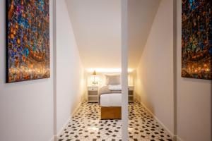 a room with two paintings on the wall and a bed at Heritage Hotel Lucia in Dubrovnik