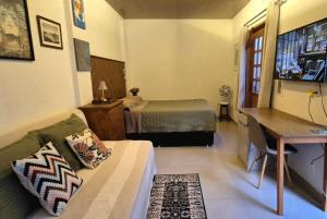 a bedroom with a bed and a desk with a desk at Estúdio aconchegante com cozinha externa e quintal in Morro do Chapéu