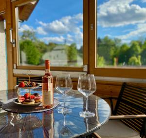 a table with a bottle of wine and two wine glasses at Ferienwohnung Lea La Milan in Stockach