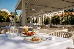 a table with plates of food and wine glasses at Heritage Hotel Lucia in Dubrovnik