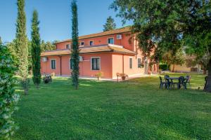 an orange building with tables and chairs in a yard at Capracotta in Montemassi