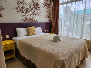 a bedroom with a bed with a hat on it at Park Place Hotel in Siguatepeque