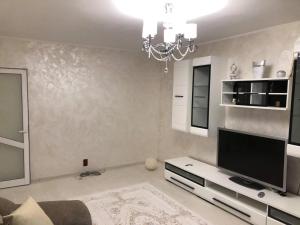 a living room with a television and a chandelier at AmiraHome in Galaţi