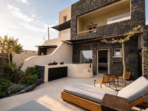 a patio of a house with a bed and chairs at Santa Mar ECO Suites in Karterados