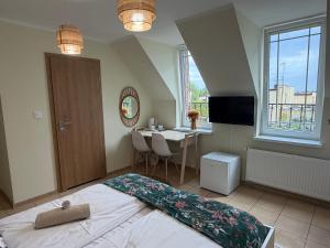 a bedroom with a bed and a desk and a window at Wilczy Zaułek in Mielno