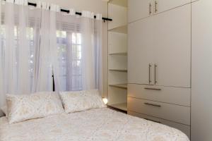 a bedroom with a white bed and a window at Cote Cottage in Somerset West