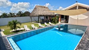 a swimming pool with chairs and a house at Villa Esmeralda del Mar in Monte Gordo